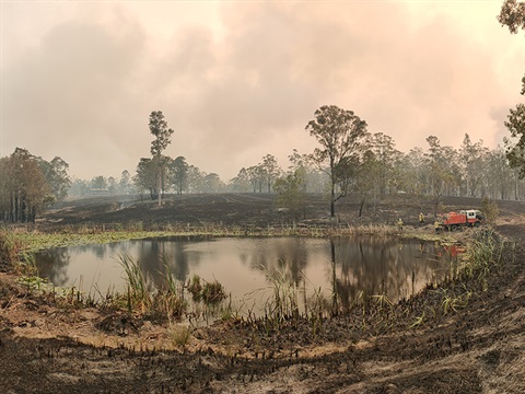 A nsw rural fire service truck refilling at a local dam during the black summer busfires